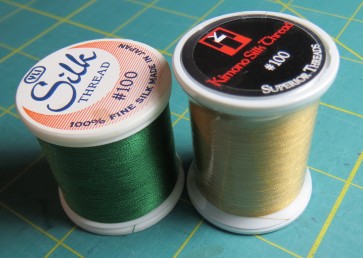 YLI and Superior make size 100 silk threads, good for applique and machine quilting
