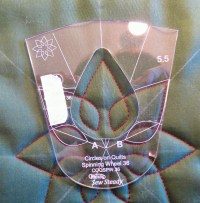 spinning wheel template placed over stitched out design